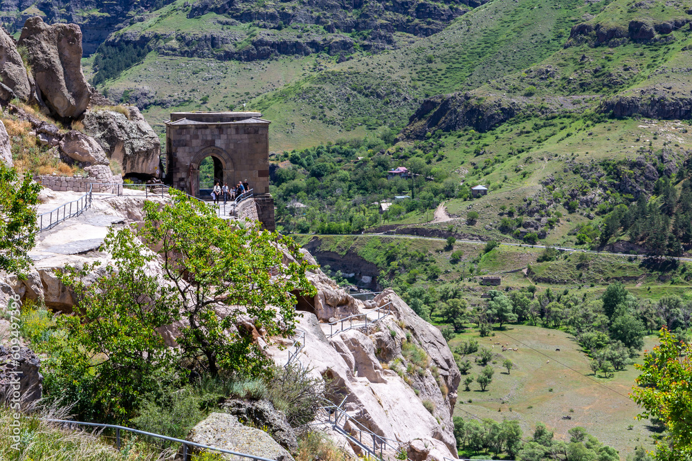 Bell Tower building in Vardzia cave monastery complex in Georgia, mountain slope with carved ancient caves, Kura river valley in the background.
