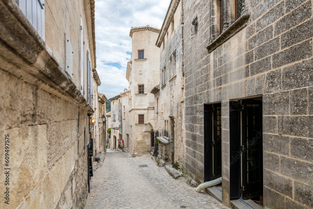 A typical narrow stone street through the historic medieval village of Les Baux-de-Provence in the Alpilles Mountains of the Provence-Alpes-Cote d'Azur region of Southern France.	