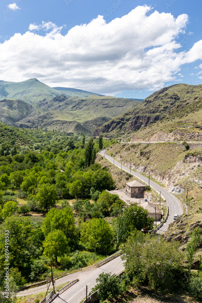 Winding tarmac road (historic silk road) through Khertvisi village in Mtkvari river valley in Lesser Caucasus Mountains, Samtskhe - Javakheti region, Georgia, seen from Khertvisi fortress.