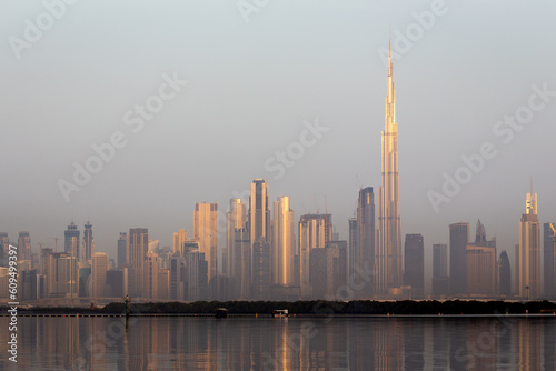 Dubai Downtown skyline landscape with the skyscrapers reflecting golden sun and reflections in Dubai Creek  sunrise.