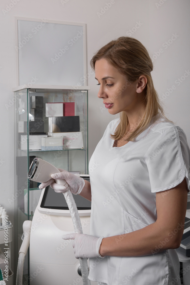 Laser device for removing unwanted hair in the hand of nurse. Laser hair removal, cosmetic body treatments. Concept of hygiene, beauty, health. Girl holding a working part of the epilator in her hands Laser device for removing unwanted hair in the hand of nurse. Laser hair removal, cosmetic body treatments. Concept of hygiene, beauty, health. Girl holding a working part of the epilator in her hands
