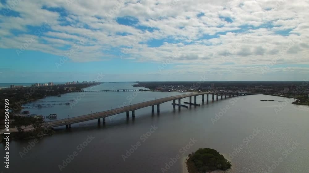 Aerial Panning Shot Of Vehicles On Bridge Over Sea Against Sky, Drone Flying Over City On Sunny Day - Daytona Beach, Florida Aerial Panning Shot Of Vehicles On Bridge Over Sea Against Sky, Drone Flying Over City On Sunny Day - Daytona Beach, Florida
