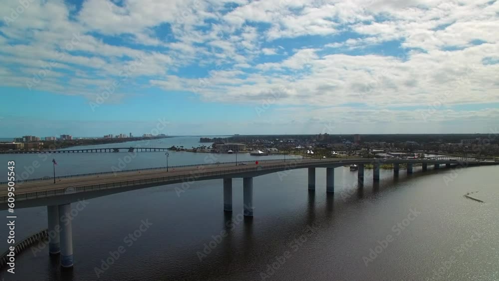 Aerial Shot Of Cars On A Bridge Over Sea Against Sky, Drone Flying Backward Over City On Sunny Day - Daytona Beach, Florida Aerial Shot Of Cars On A Bridge Over Sea Against Sky, Drone Flying Backward Over City On Sunny Day - Daytona Beach, Florida