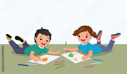 Happy little kids drawing painting together lying on the floor