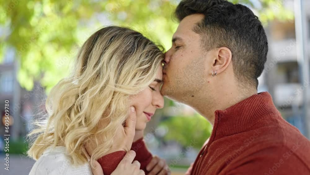 Man and woman couple smiling confident kissing on head at park Man and woman couple smiling confident kissing on head at park