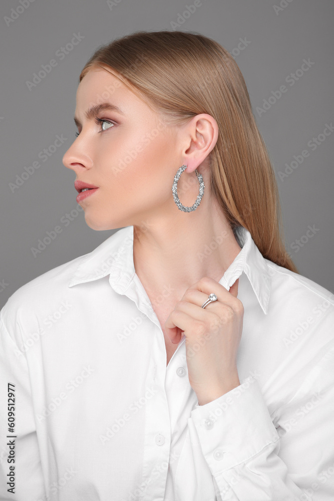 Beautiful young woman with elegant jewelry on gray background Beautiful young woman with elegant jewelry on gray background