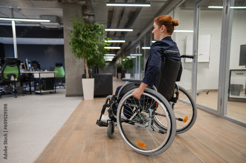 Caucasian woman wheelchair in open space office. Caucasian woman wheelchair in open space office.