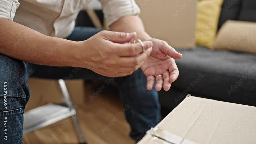 Young hispanic man holding new house keys at new home Young hispanic man holding new house keys at new home