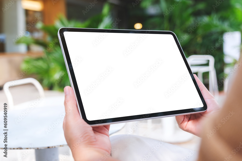 Mockup image of a woman holding digital tablet with blank white desktop screen in the outdoors cafe Mockup image of a woman holding digital tablet with blank white desktop screen in the outdoors cafe