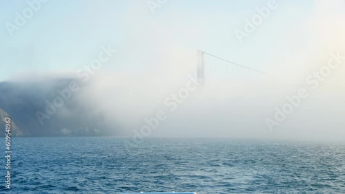 Golden Gate Bridge support is barely visible through thick fog, Pacific Ocean
