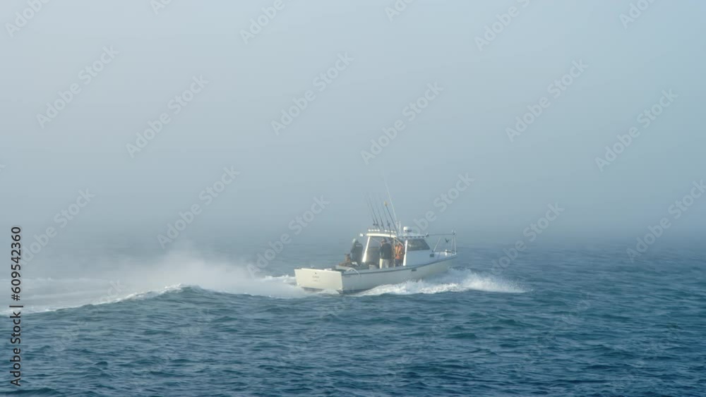 Fishing boat heads out to sea in Pacific Ocean during early morning fog