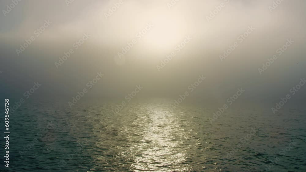 Breathtaking early morning view of ocean with thick fog creating a magical haze Breathtaking early morning view of ocean with thick fog creating a magical haze