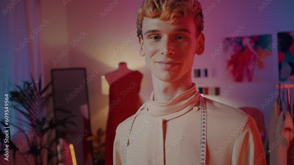 Stylish tailor, fashion designer, dressmaker with centimeter around his neck at tailoring atelier Stylish tailor, fashion designer, dressmaker with centimeter around his neck at tailoring atelier