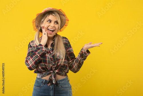 Beautiful brazilian woman, with festa junina clothes, on yellow background