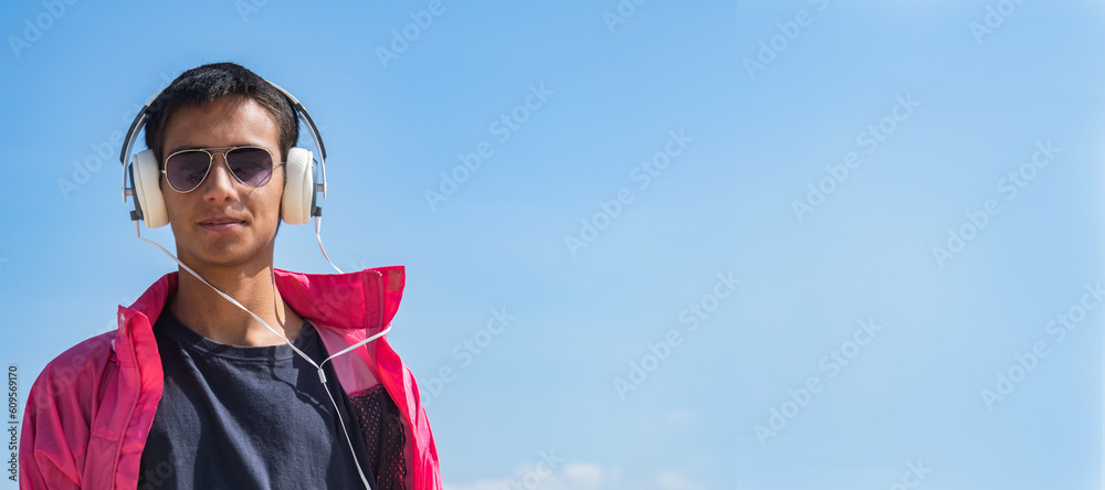 young man with headphones on blue background young man with headphones on blue background