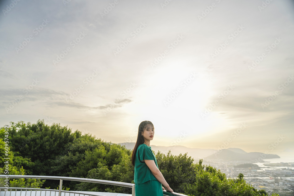 Fototapeta premium 夕陽の空と若い女性