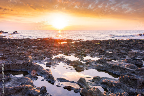 beautiful golden sunset or sunrise on a seashore bank with blue sea water and yellow sunnny evening cloudy sky