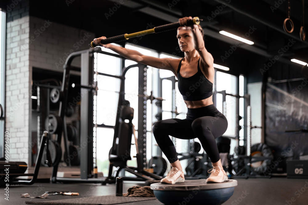 Sporty woman making squats on balance trainer. Sporty woman making squats on balance trainer.