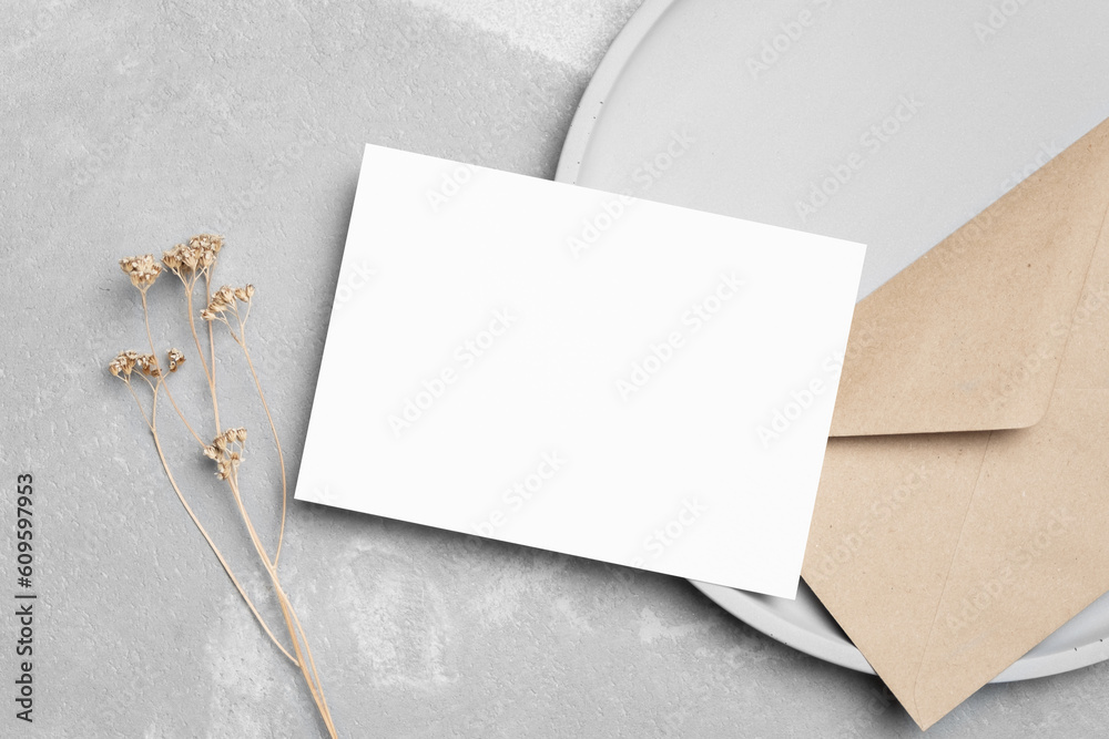 Blank white invitation card mockup with envelopea and dry flowers decor on grey background, copy space Blank white invitation card mockup with envelopea and dry flowers decor on grey background, copy space