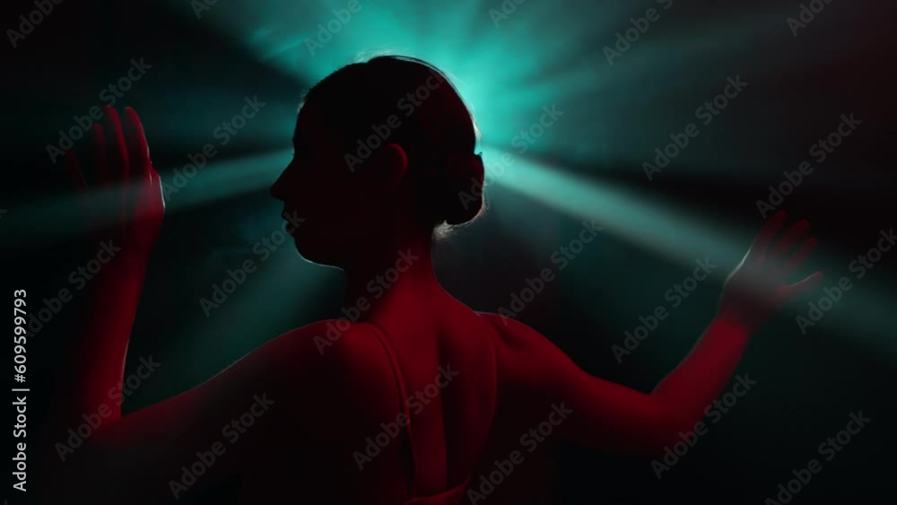 Solo performance by talented female performer, infusing stylish improvisation and classic ballet choreography in abstract modern dance. Dancer girl gracefully moves in light rays in slow motion