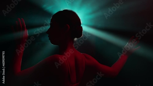 Solo performance by talented female performer, infusing stylish improvisation and classic ballet choreography in abstract modern dance. Dancer girl gracefully moves in light rays in slow motion