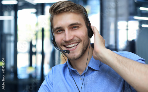 Obraz na płótnie Smiling friendly handsome young male call centre operator