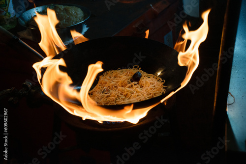 Wok with padthai at flames from traditional food market and bazar in Thailand photo