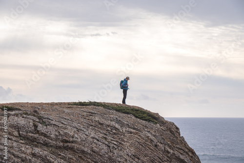 Travel enthusiast enjoys his freedom in the Portuguese countryside on the Atlantic coast observing the endless sea and the shapes of the cliffs. Wandering the Fisherman Trail