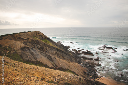 Rocky cliffs with futuristic patterns on the Atlantic coast near the town of Aljezur in southwestern Portugal. The sound of the ocean as the sun sets. Wandering the Rota Vicentina