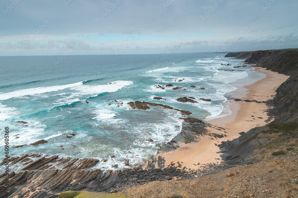 Famous Praia da Carreagem beach in the southwest of Portugal, near the town of Aljezur in the Odemira region. The waves of the Atlantic Ocean crash on the sand. Wandering the Fisherman Trail