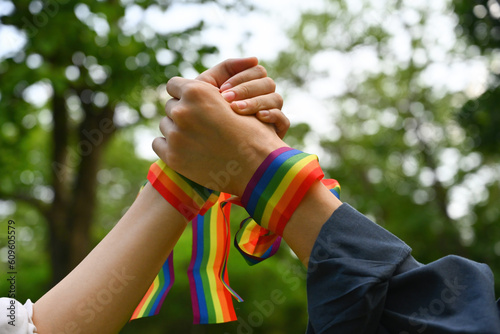 A hands with rainbow wristband holding and joining hands together, Support and celebrate the LGBT community.