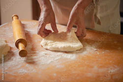 Women's hands make pasty dough