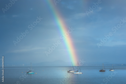 Beautiful rainbow in the sky arching over fishing boats and the Firth of Forth in the quaint village of Aberdour, Fife, Scotland, UK. © Stephen