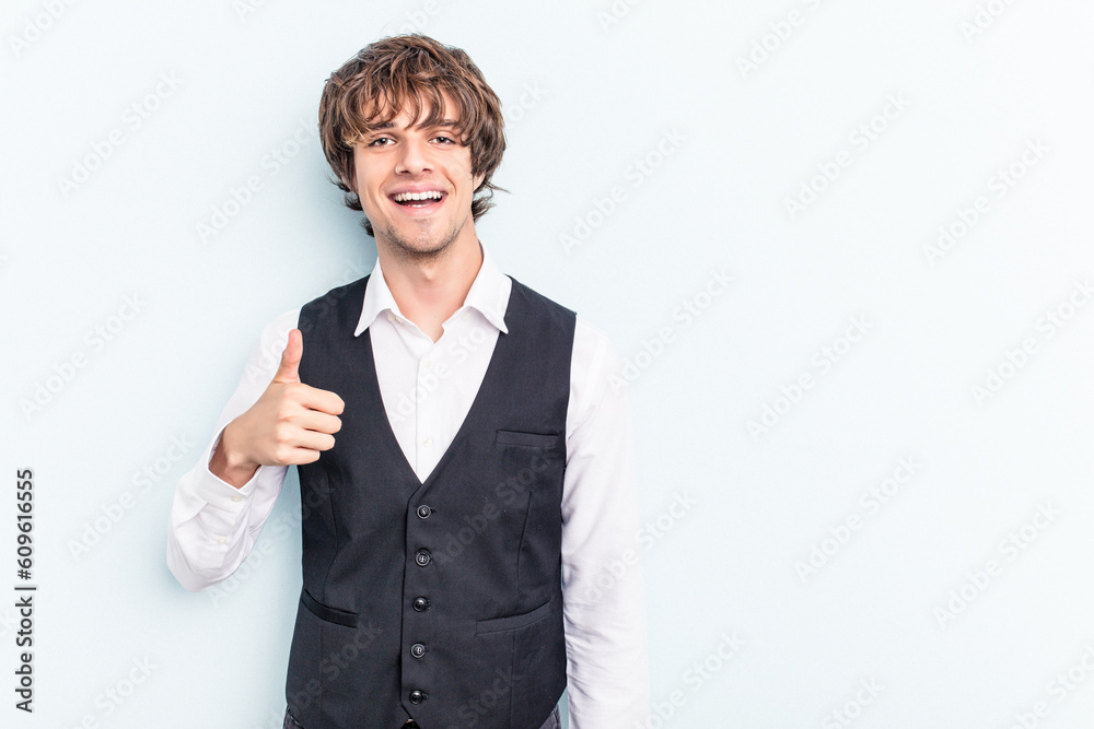 Young caucasian waitress man isolated on blue background smiling and raising thumb up Young caucasian waitress man isolated on blue background smiling and raising thumb up