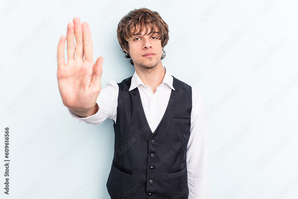 Young caucasian waitress man isolated on blue background standing with outstretched hand showing stop sign, preventing you. Young caucasian waitress man isolated on blue background standing with outstretched hand showing stop sign, preventing you.