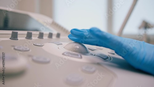 A gynecologist uses a transvaginal ultrasound device presses buttons takes a picture of the patient's internal organs in the clinic close-up