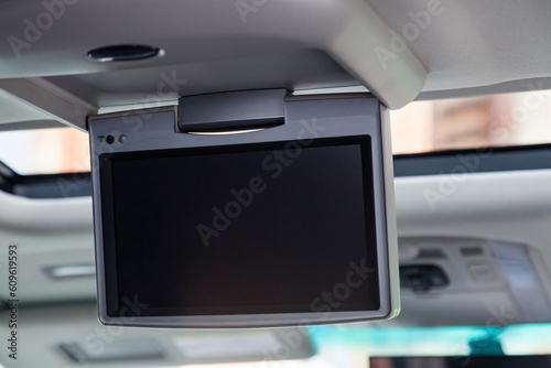 Entertainment system for rear passengers in a car with monitor mounted on the ceiling for watching TV, cartoons and computer games.