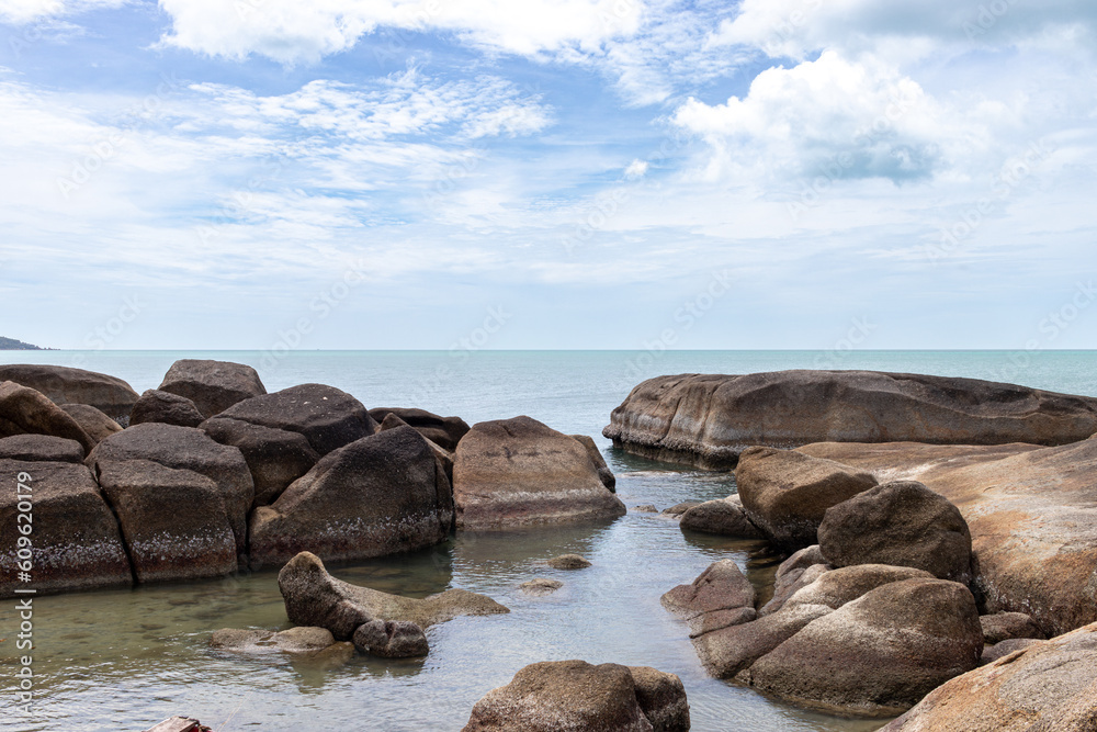 a rockpool formation off a phuket beach with still water