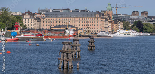 Fotografie Three old wood dolphins and old sailing boats moored at a pier on the maritime i