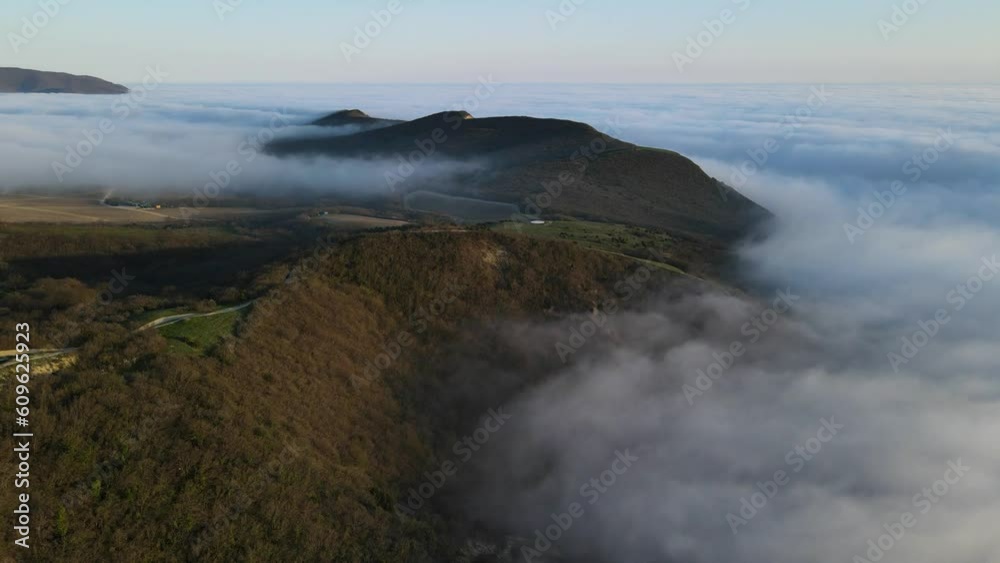Aerial drone view of creeping fog with evening light. Foggy weather in mountains Aerial drone view of creeping fog with evening light. Foggy weather in mountains