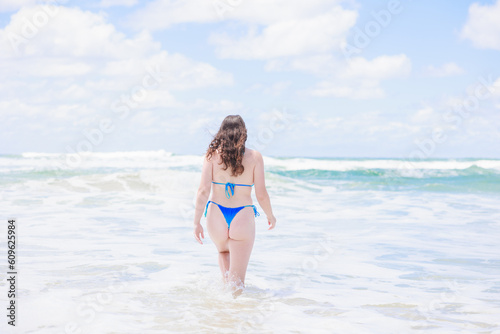 海につかる水着姿のオーストラリア人女性の後ろ姿