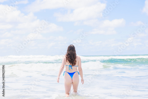海につかる水着姿のオーストラリア人女性の後ろ姿 © photok