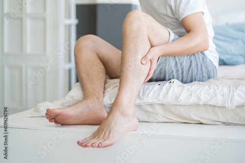 Tableau sur toile The man's calf muscle cramped, massage of male leg at home