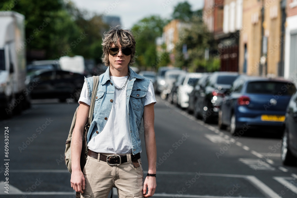 Androgynous person looking at camera on the road.
