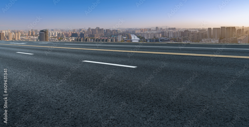 Fototapeta premium Asphalt pavement and urban building skyline