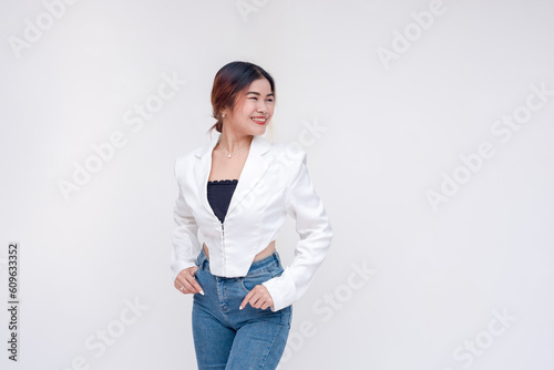 A young woman posing in front of the camera looking sideways to the right. Isolated on a white background.