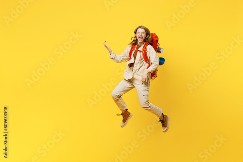 Fototapeta Naklejka Na Ścianę i Meble -  Full body young woman carry bag with stuff mat jump high pov play guitar isolated on plain yellow background. Tourist leads active lifestyle walk on spare time. Hiking trek rest travel trip concept.
