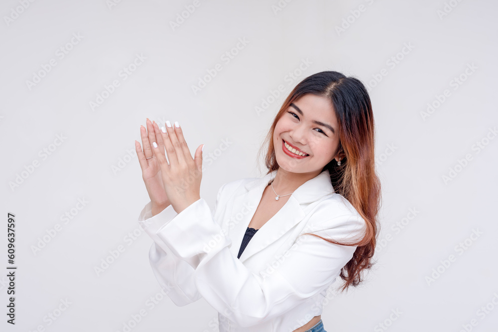 A young woman with head tilted clapping while looking at the camera. Isolated on a white background. A young woman with head tilted clapping while looking at the camera. Isolated on a white background.