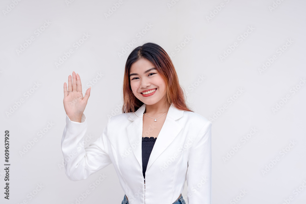 A smiling young woman with one hand raised as an act of taking oath. Isolated on a white background. A smiling young woman with one hand raised as an act of taking oath. Isolated on a white background.