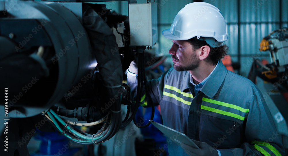 Professional industrial engineer, technician, factory worker wear hard hat safety. While set up, control machine heavy industry factory. Employee working in manufacturing facility